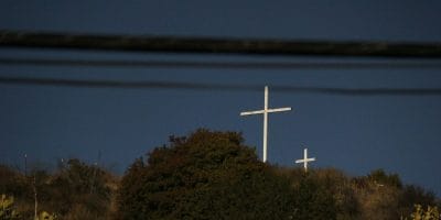A white cross on top of a hill