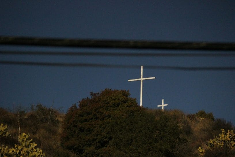 A white cross on top of a hill