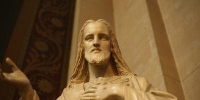A statue of jesus holding his hands up