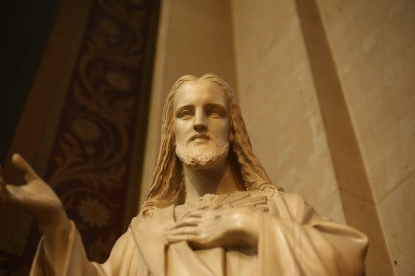 A statue of jesus holding his hands up