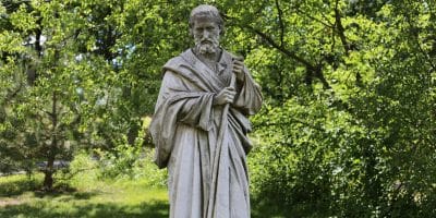 man statue near green trees during daytime